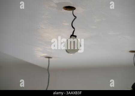 Exposed ceiling wires and downlights during renovation—capturing the raw phase of electrical installation and modern home interior upgrades Stock Photo