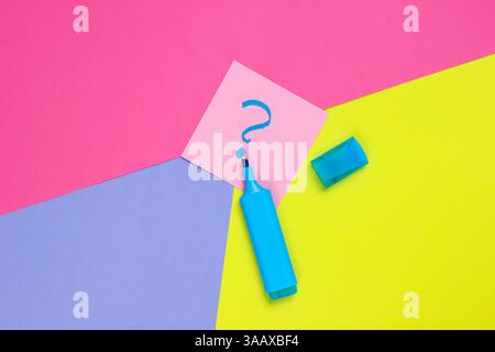 Memo piece of paper with drawn question marks, felt-tip pen on colored background. Top view. Minimalism Stock Photo
