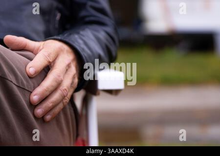 Mature elderly man resting outdoors. Senior person in his sixties sitting on a chair. Camping lifestyle of a retired male. Closeup of an older man  ha Stock Photo