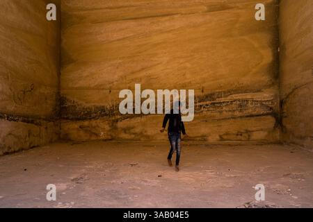 WADI MUSA, JORDAN - 10 SEPTEMBER 2021: Kid inside of a cave on Little Petra. CREDIT: Daniel Rodrigues Stock Photo