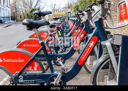 A row of Santander cycles for hire, parked by the roadside in Islington, London, UK Stock Photo
