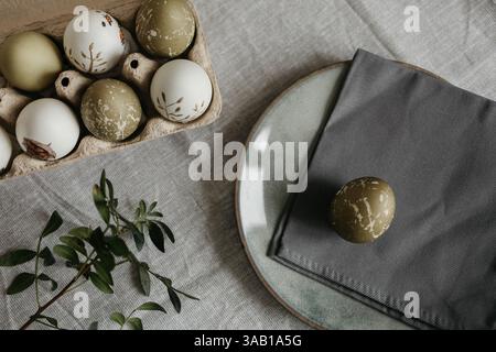 Easter holiday. Painted olive-colored eggs on a linen tablecloth. Easter decoration. Stock Photo