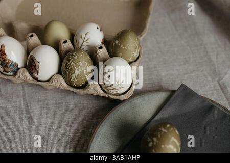 Easter holiday. Painted olive-colored eggs on a linen tablecloth. Easter decoration. Stock Photo