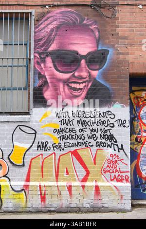 Street art on wall in Whitechapel London featuring magenta woman with sunglasses and comment on war and economic growth Stock Photo