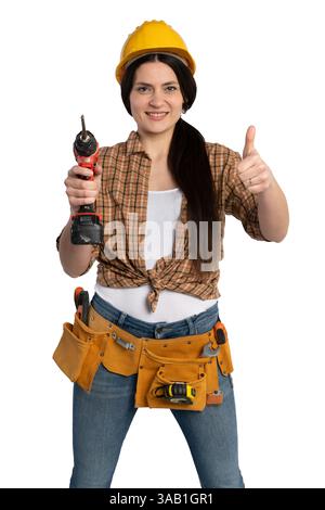 Confident female construction worker wearing a yellow safety helmet, holding a power drill, and giving a thumbs-up, symbolizing success and expertise Stock Photo