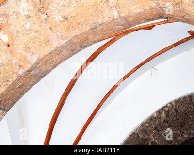 An artistic view of a curved architectural feature, showcasing a blend of natural stone and smooth white surfaces. The design highlights contrasting t Stock Photo