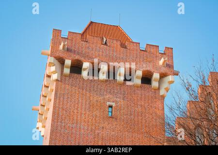 Red Brick Castle Tower Captured from Below Against a Clear Blue Sky Stock Photo
