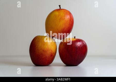 3 apples stacked to make a pyramid on a white background. Stock Photo
