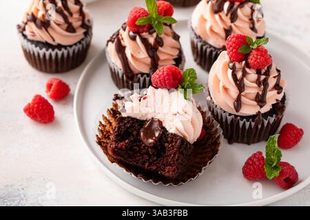 Raspberry chocolate cupcakes with raspberry buttercream and chocolate filling Stock Photo