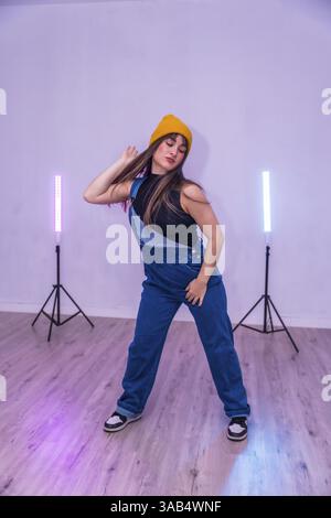 Female dancer practicing a modern choreography in a dance studio with colorful led lights Stock Photo