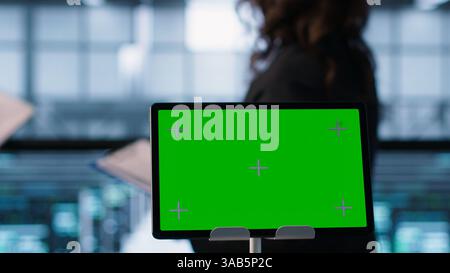 Close up of chroma key tablet next to server room data scientists conducting security audits, preventing bugs. Green screen device and man working with colleague in data center, camera A Stock Photo