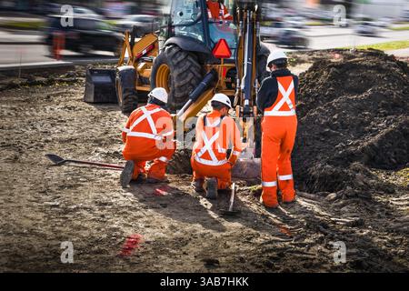 Four workers team is digging pit on construction site project Stock Photo