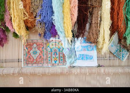 Thread color samples and a weaving patter on a traditional loom. At the Samarkand Bukhara Silk Carpets Factory store in Uzbekistan. Stock Photo