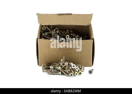 A box of screws sits on a white background with screws spilled out on the surface for use in building or home repair projects. Stock Photo