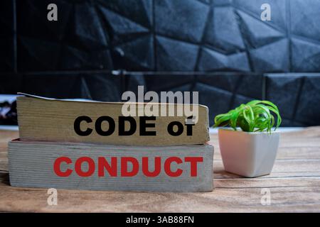 Books with words Code of Conduct on wooden table and black background Stock Photo