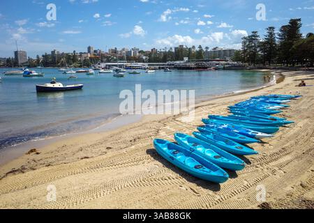 Colourful canoe boats lined up on East Manly Cove Beach near Manly Wharf in Sydney, Australia Stock Photo
