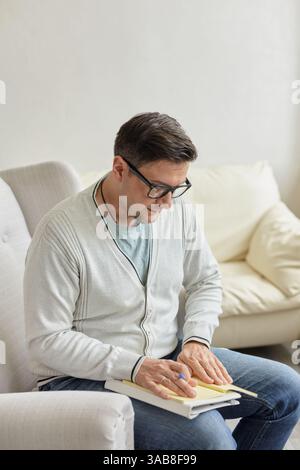 Portrait of handsome male psychologist and taking notes during therapy session at clinic. Friendly millennial psychotherapist posing and smiling at of Stock Photo