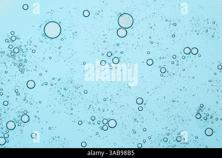 A collection of blue liquid bubbles floating on a clear backdrop, creating an abstract and calming visual. Ideal for backgrounds, textures, and cosmet Stock Photo