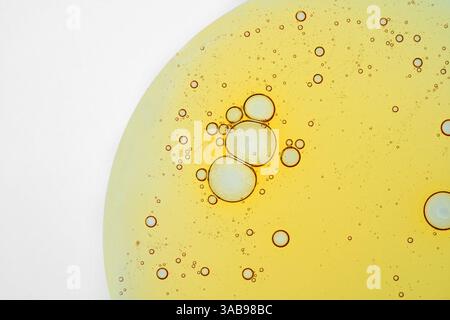 Close up of oil bubbles for cosmetic creating a unique pattern against a smooth white backdrop. The bubbles showcase varying sizes, textures and trans Stock Photo