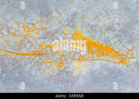 Abstract aerial view of cracked earth showcasing vibrant orange and gray hues, creating an intricate pattern resembling a natural mosaic in a desert e Stock Photo