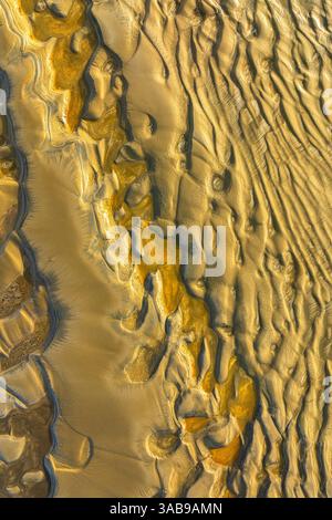 Aerial view of wind sculpted patterns in golden sandy terrain. Natural textures create abstract landscapes, highlighting the beauty and complexity of Stock Photo