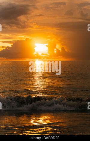 Breathtaking sunset over the ocean in Bali, Indonesia. Golden hues reflect on the sea, creating a mesmerizing and peaceful atmosphere. Perfect for tra Stock Photo