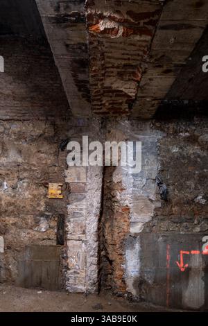 Exposed brick and concrete wall featuring signs of ongoing construction. Visible repairs highlight the texture and aged look, symbolizing a work in pr Stock Photo