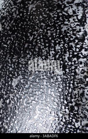 Hammered Dark Steel Helmet Texture. Close-up of medieval armor showing uneven metal surface. Stock Photo