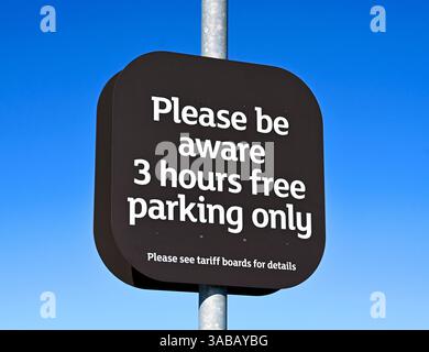 Free parking information sign. Car park, Sainsbury's  and Argos Supermarket. Shap Road, Kendal, Cumbria, England, United Kingdom, Europe. Stock Photo