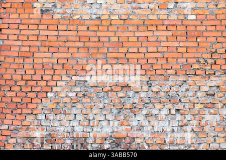 Rustic brick wall showcasing aged texture and vibrant color variations under sunlight. Stock Photo