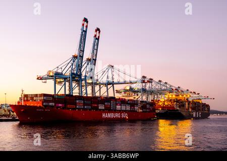 Gibraltar, UK - December 26, 2023: Container ship in the port during sunset Stock Photo