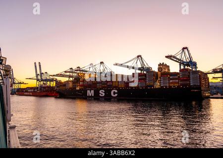 Gibraltar, UK - December 26, 2023: Container ship in the port during sunset Stock Photo