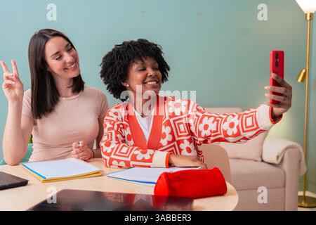 African American and Caucasian students taking selfie while studying at home Stock Photo