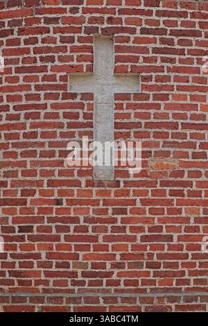 A white cross made into red brick wall. Stock Photo