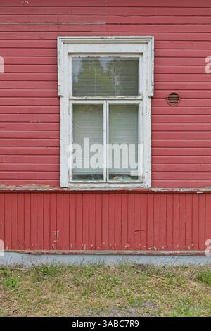 Old white framed window on red painted wooden wall. Stock Photo