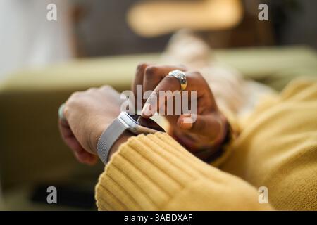 Close-up of person using smartwatch for checking time and notifications. Modern technology with blurred background and soft focus on hand and gadget Stock Photo