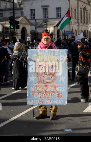 Pro-Palestine protester with anti President Trump sign, at a rally calling for a permeant ceasefire of the ongoing military actions in Gaza by Israeli Stock Photo