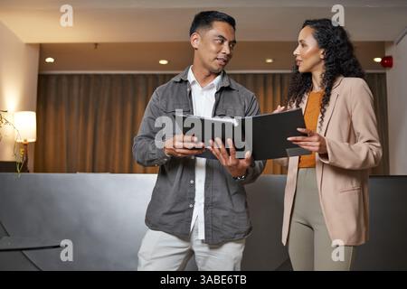 Professionals Collaborating in a Hotel Lobby for a Business Presentation Stock Photo