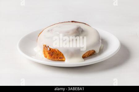 freshly baked sweet cinnamon roll on white plate Stock Photo
