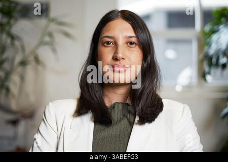 Confident Professional Woman in Business Attire in a Bright Office Space Stock Photo