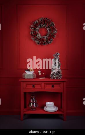 Christmas wreath hanging on a wall over a Sideboard decorated with Christmas ornaments Stock Photo