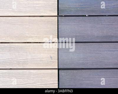 Two pieces of wood with a white and a gray stripe. The white wood is more worn and has a few scratches, while the gray wood is newer and smoother Stock Photo