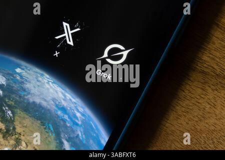 App icons of Grok, xAI's chatbot, and X are seen on the screen of an iPhone. Elon Musk sells X, formerly known as Twitter, to xAI, his own AI lab. Stock Photo