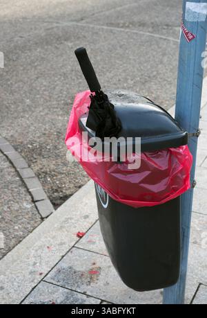 broken umbrella sticking out of a trash bin Stock Photo