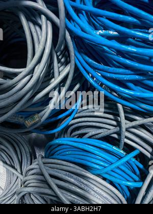 bundle of blue and grey unused rolled LAN cable or network cable as background Stock Photo