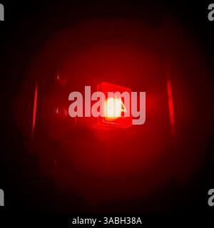 close up view of a button with bright red light shining in the dark background Stock Photo