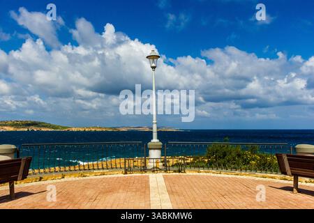 Scenic Coastal View With Benches and Lamp Post Under a Bright Blue Sky Stock Photo