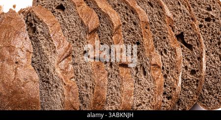 Fresh sliced Sourdough Bread as background close up. Yeast rye or wheat artisan bread texture. Stock Photo
