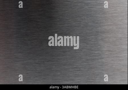 Close-up of smooth gray metal surface showcasing brushed texture and light reflections that enhance its depth. Stock Photo