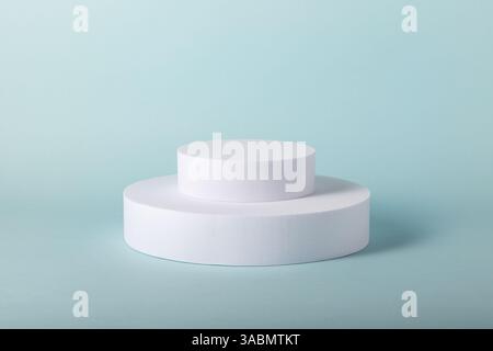 Showcase props for online marketing. Minimal concept with white round stands on blue background. Stock Photo